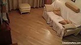 Frau in schwarzen Strapsen masturbiert auf der Couch